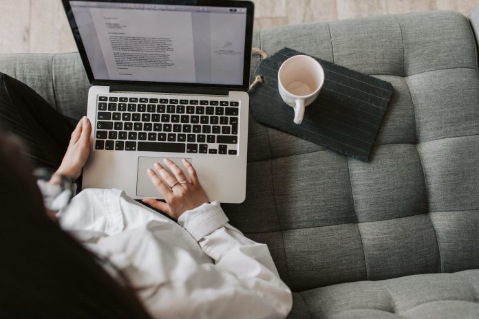 Woman sitting on a couch writing a marketing strategy, copywriting